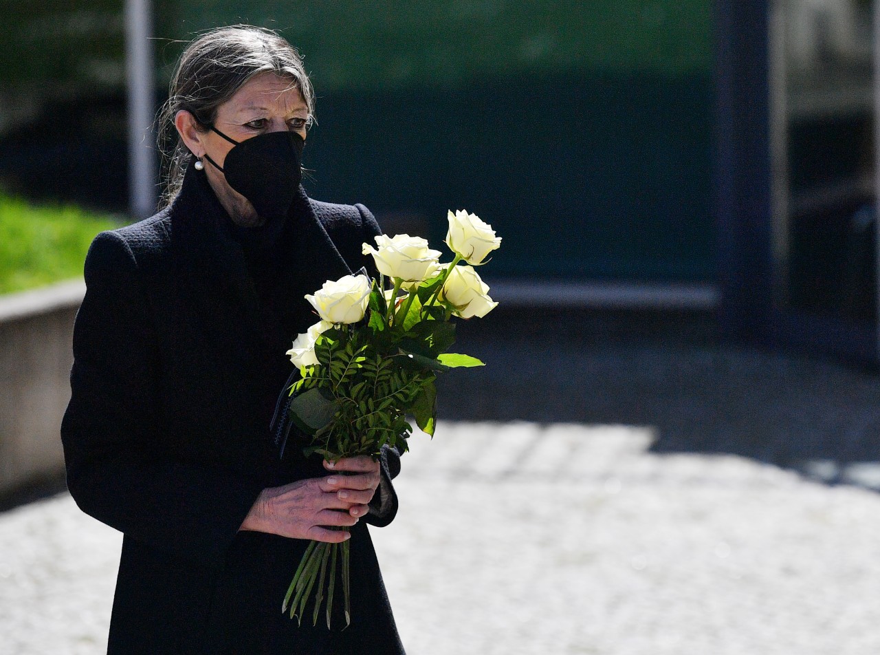 Christiane Alt, Schulleiterin des Gutenberg-Gymnasiums, hält 19 Jahre nach dem Amoklauf an dem Gymnasium bei einem stillen Gedenken einen Rosenstrauß in den Händen