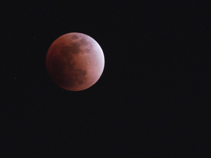 Bei diesem Foto aus Tokio kann man sehen, warum auch von einer „Blutmondfinsternis“ die Rede ist: Als sich die Erde zwischen Sonne und Mond schob, tauchten die langwelligen, um die Erde herumragenden Sonnenstrahlen den Mond in ein sanftes, dunkelrotes Licht.