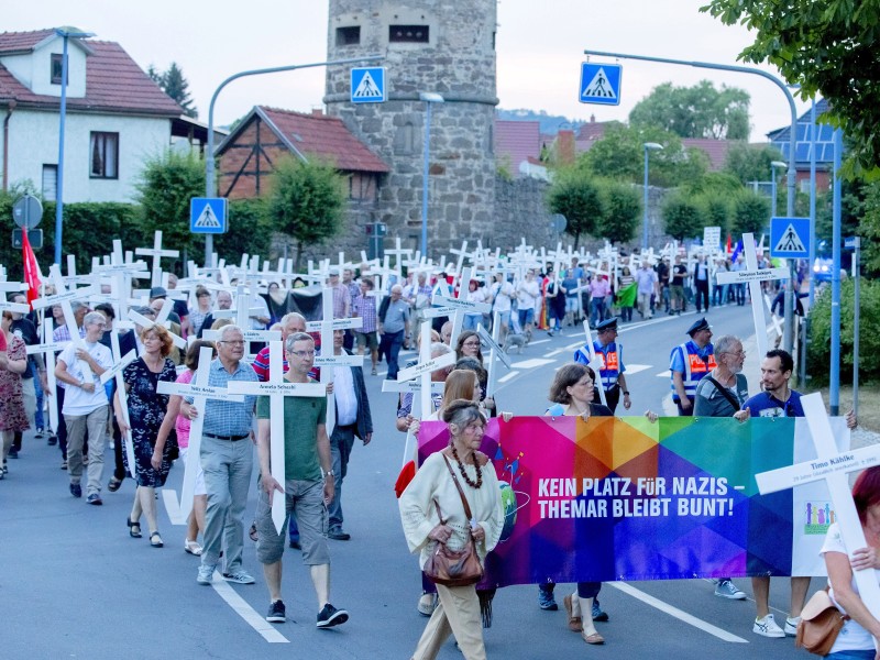Der Zug der Gegendemonstration zum Festival zieht mit weißen Kreuzen und Bannern am Freitag durch Themar. Die Kreuze sollen an Opfer rechter Gewalt erinnern. 