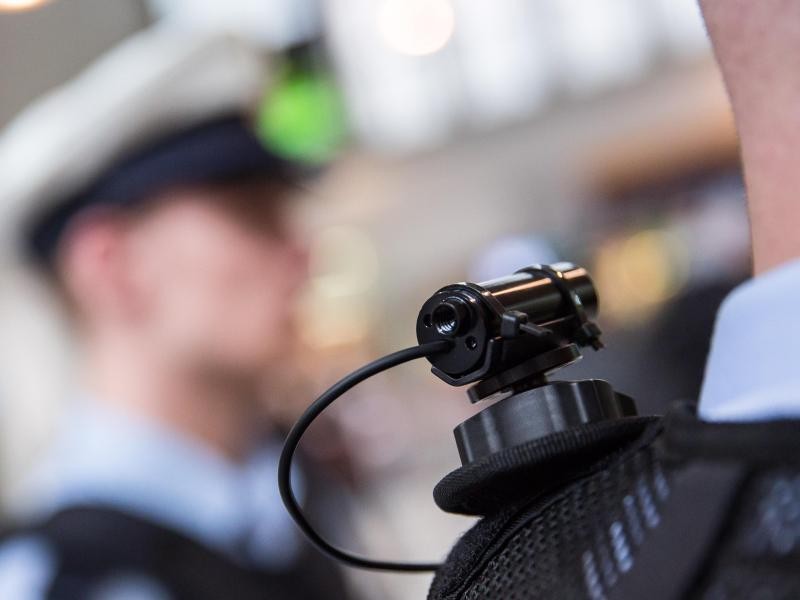 Ein Polizeibeamter trägt eine Body-Cam auf seiner Schulter. (Archivfoto)