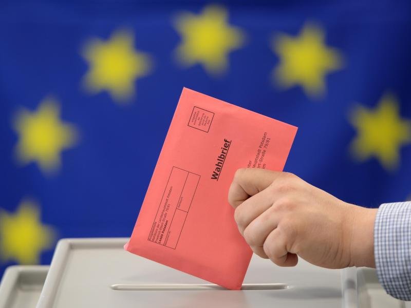 Ein Wahlbrief zur Europa-Wahl wird in eine Wahlurne eingeworfen.