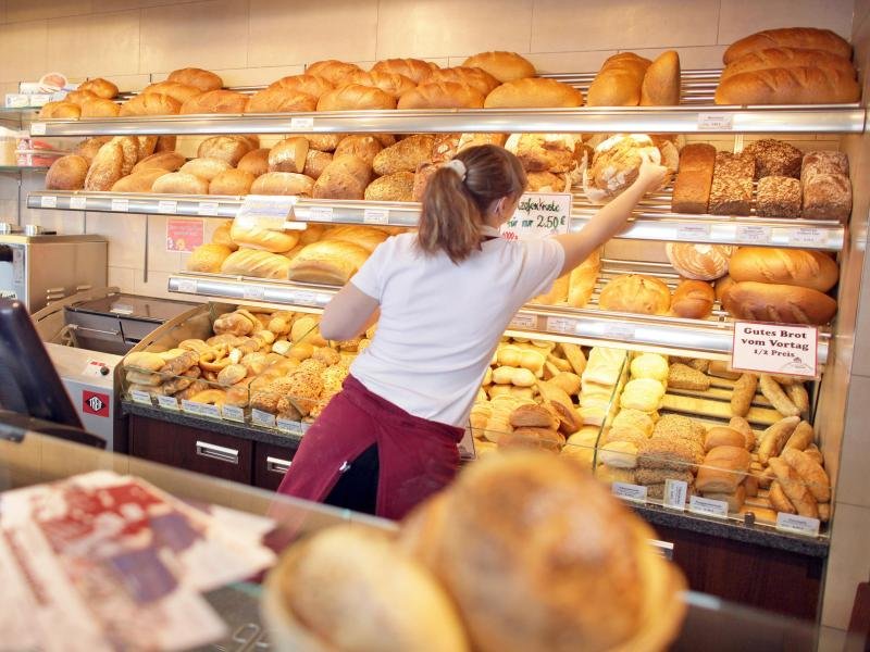 Eine Verkäuferin sortiert Brot in einer Bäckerei. Deutsche Betriebe suchen zur Zeit viele Arbeitskräfte.