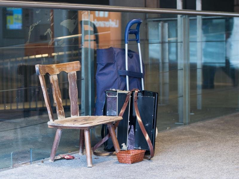 Etwas dazuverdienen: Der leere Stuhl eines Straßenmusikers steht in Stuttgart neben einem Akkordeon.