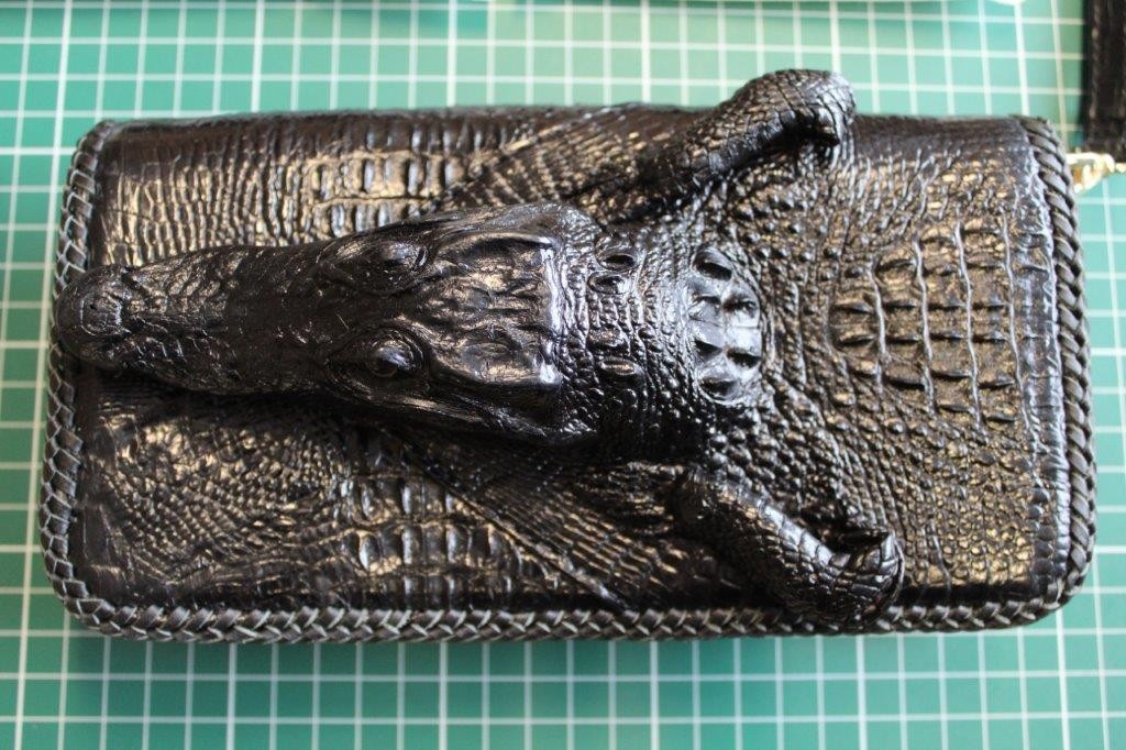 Kopf eines Krokodils als Applikation auf einer Handtasche.