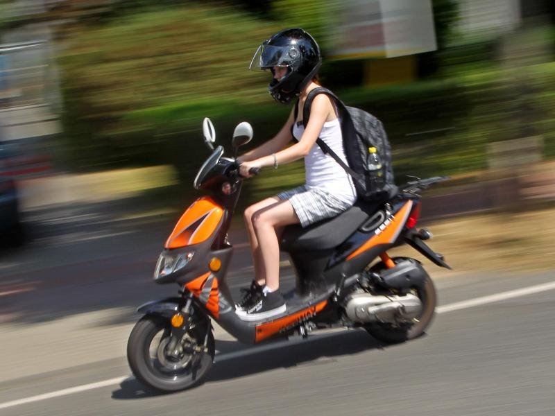 Junge Frau auf Moped