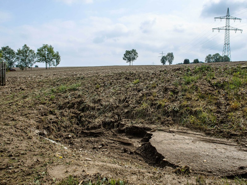 Eine Schlammlawine hat sich durch Tiefurt, einen Ortsteil von Weimar, gewälzt. Das Erdreich hatte sich am Freitagabend (17.08.2018) gelöst, als ein schweres Unwetter über die Region zog. Ein kurzer, aber heftiger Starkregen spülte das Material von einem Feld durch mehrere Grundstücke. Am Tag danach machten sich die Anwohner an die Aufräumarbeiten. Das Unwetter hatte auch an anderen Stellen in Weimar für Schäden gesorgt. So stürzte in der Innenstadt in einer Wohnung durch Wassereinbruch eine Zimmerdecke ein; von Bäumen brachen viele Äste ab, in einen davon fuhr ein Linienbus. Der Park an der Ilm sowie die Parks in Tiefurt und Belvedere wurden gesperrt.