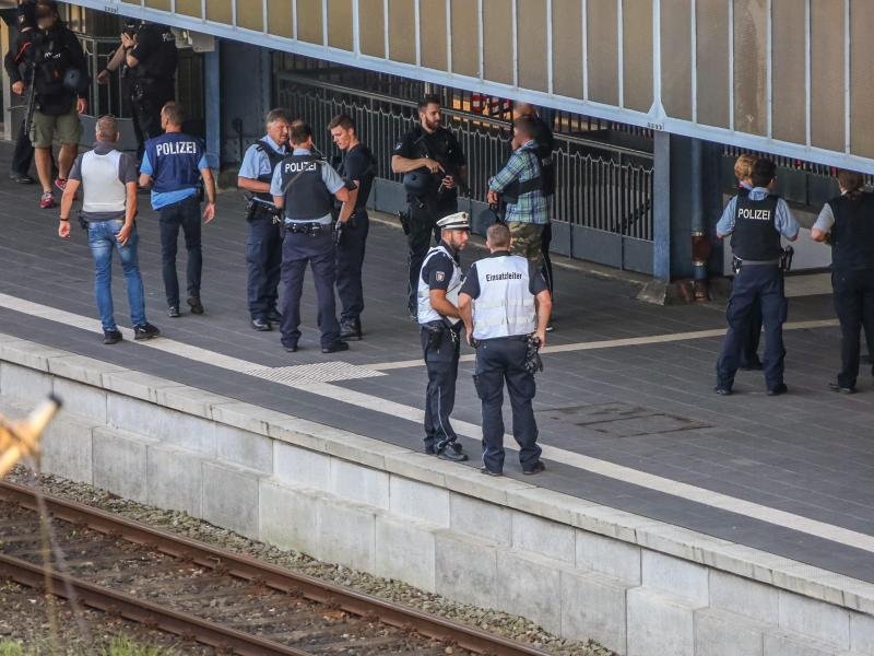 Polizisten sichern nach einem Zwischenfall mit einem Toten den Bahnsteig auf dem Flensburger Bahnhof.