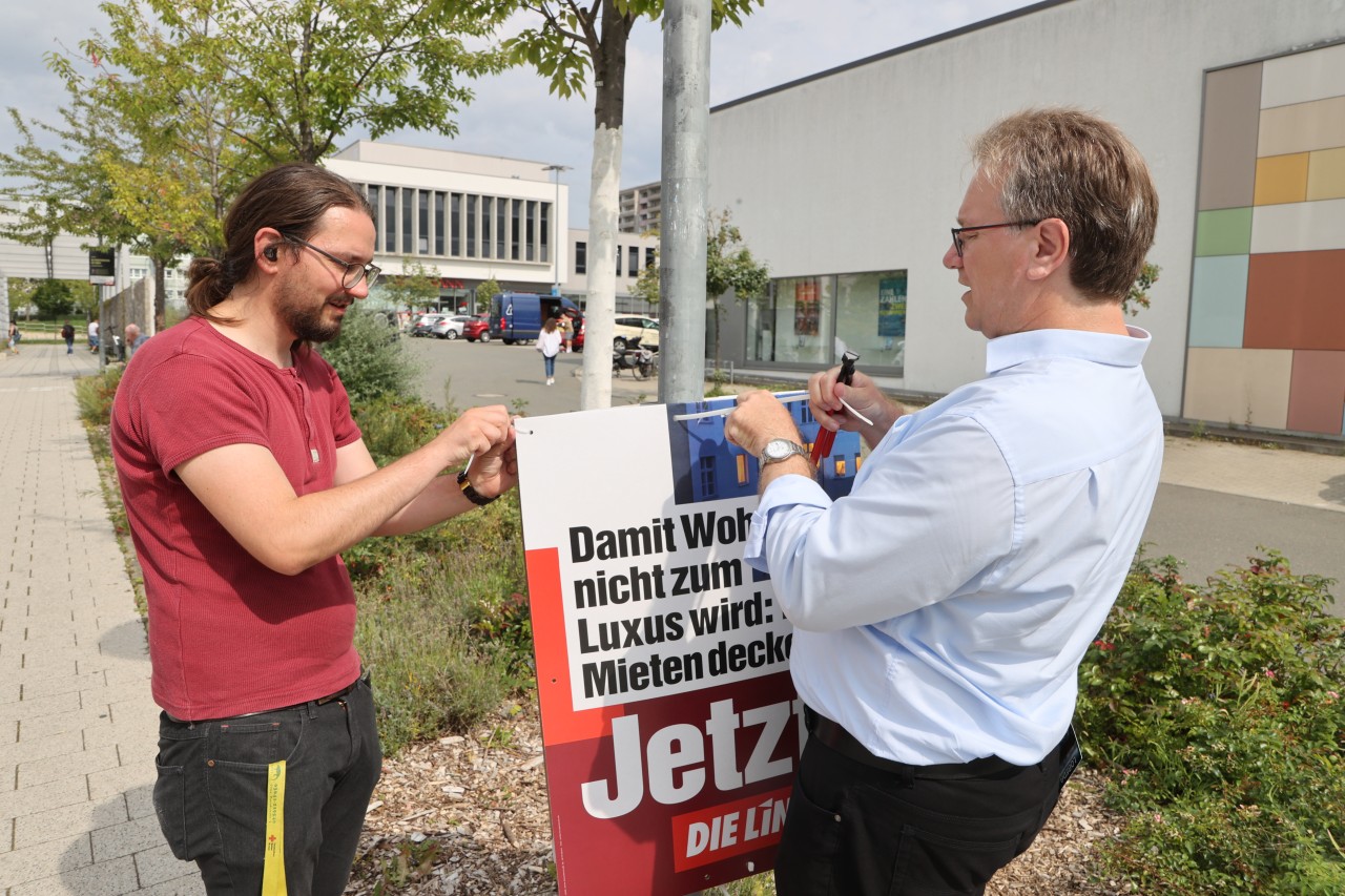 Ralph Lenkert (rechts), Bundestagskandidat der Linken, und Felix Ihle hängen im Wohngebiet Lobeda Wahlplakate ihrer Partei Die Linke auf. Die Thüringer Parteien haben Angst vor Zerstörungswut. 