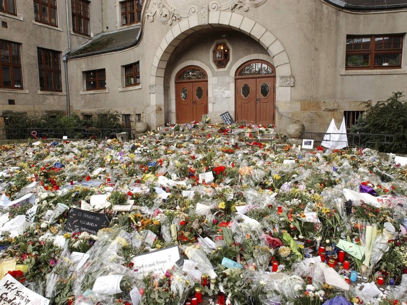 Blumen liegen vor dem Gutenberg-Gymnasium in Erfurt zu Ehren der Opfer des Amoklaufs eines Schülers.