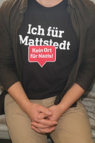 Eine Teilnehmerin eines Gottesdienstes in der Kirche der Gemeinde trägt ein T-Shirt mit der Aufschrift Ich für Mattstedt - Kein Ort für Nazis!. 