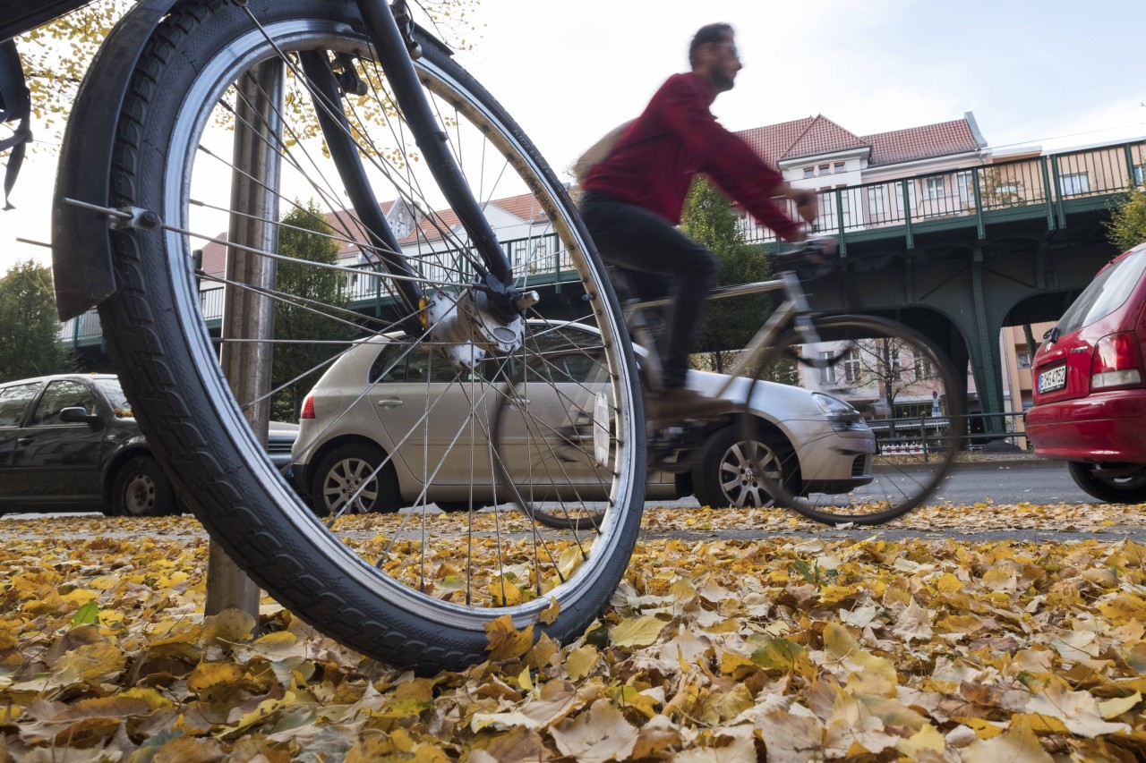 Ein Radfahrer und Fußgänger sollten im Herbst aufpassen, rät der TÜV. (Symbolbild)