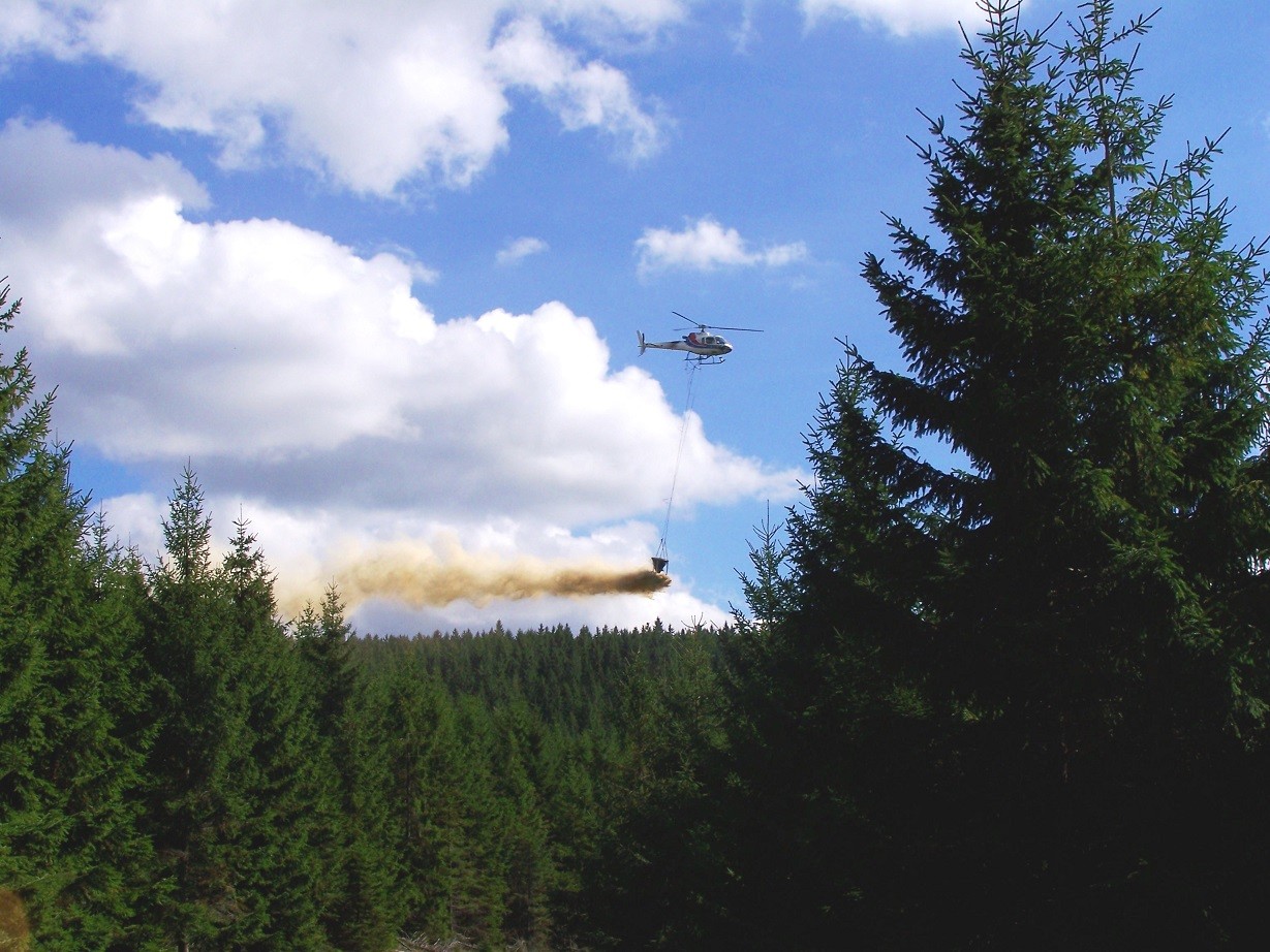 Mit einem Hubschrauber wird über dem Thüringer Wald Kalk ausgeworfen. 