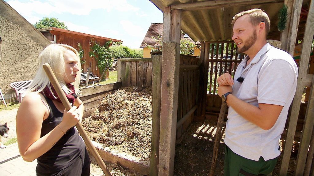 Julia und Bauer Erik reden während der Arbeit miteinander