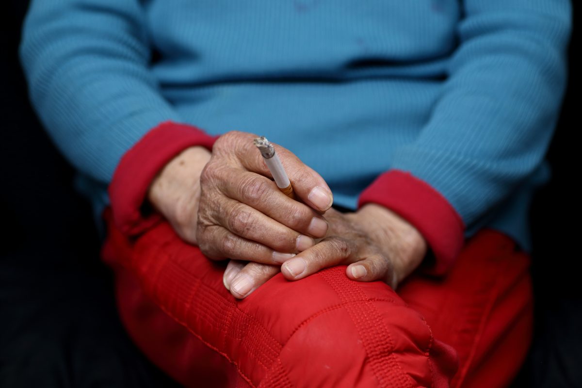 Frau hält Zigarette in der Hand