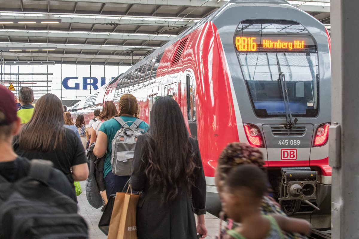 Fahrgäste vor einem Zug der Deutschen Bahn