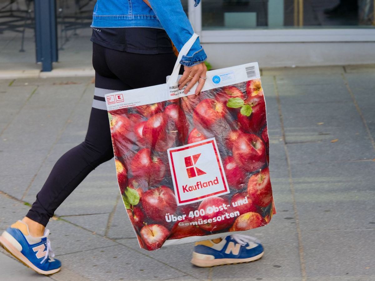 Ein Mensch trägt eine Einkaufstüte von Kaufland