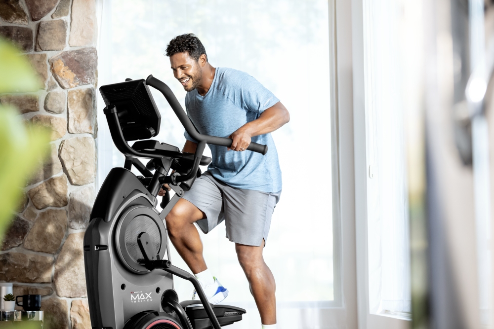 Ein Mann trainiert auf dem BowFlex Max Trainer M9.