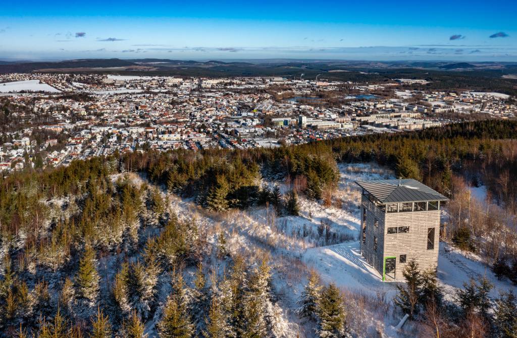 Der Aussichtsturm auf dem Lindenberg zwischen schneebedeckten Bäumen im UNESCO-Biosphärenreservat Thüringer Wald von oben